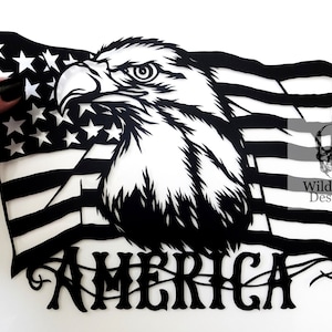Könnte beinhalten: Schwarz-weißes Papier-Ausschnitt eines amerikanischen Flagge mit einem Adlerkopf und dem Wort "AMERICA" darunter.