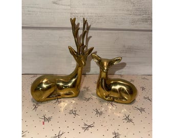 Conjunto de 2 estatuetas vintage de cervos reclinados em latão maciço, representando um macho e uma corça, estilo meados do século XX.