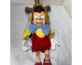 Figura animada de Pinocho de Disney que canta y se exhibe en una caja de juguetes musicales navideños de Telco.
