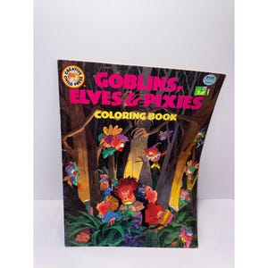Könnte beinhalten: Ein Malbuch mit dem Titel Goblins, Elves & Pixies und dem Logo von Creative Child Press. Das Cover zeigt eine dunkle Waldszene mit Zeichentrickfiguren, die Taschenlampen halten, umgeben von grünem Blattwerk und Bäumen bei Nacht.