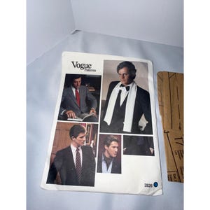 Op de afbeelding: Een Vogue Patterns naaipatroon-envelop met nummer 2826, voorzien van vier foto's van formele kleding, waaronder pakken, een witte sjaal en een stropdas. De witte papieren envelop toont de merknaam en het patroonnummer in de onderste hoek.
