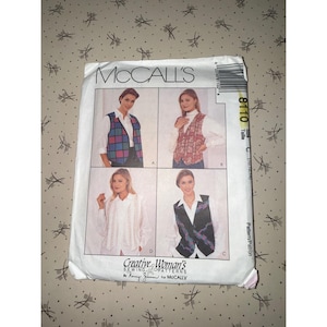 May include: A McCall's sewing pattern envelope, number 8110, featuring four variations of a sleeveless vest. The illustrations show different fabric patterns including a colorful grid, a floral print, a textured light fabric, and a dark geometric design.