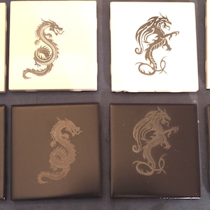 May include: Eight square ceramic tiles with different dragon designs. The tiles are in two colors: white and black. The dragons are in a variety of poses, including flying, standing, and curled up.