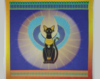 May include: Square textile featuring a black cat with gold jewelry and blue wings, set against a blue background with a sunburst design. The border is yellow, orange, and green, with Egyptian-style patterns.