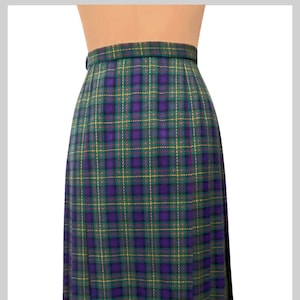 May include: A purple, green and yellow plaid skirt with a pleated design. The skirt is made of a woven fabric and has a high waist.