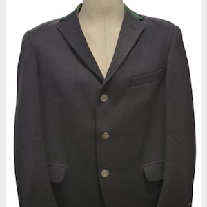 May include: A dark blue blazer with a green velvet collar and three silver buttons.