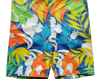May include: Blue swim trunks with a colorful tropical floral print featuring orange, yellow, green, and white flowers.