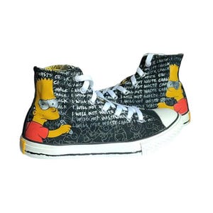 Puede incluir: Zapatillas negras de caña alta con suela blanca y un estampado gráfico de Bart Simpson de Los Simpson. El estampado incluye el texto "I will not waste chalk" repetido varias veces.