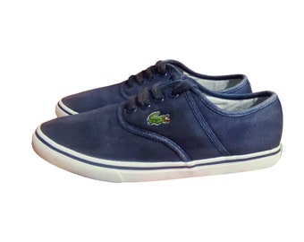 May include: A pair of dark blue canvas sneakers with white soles and a green crocodile logo.