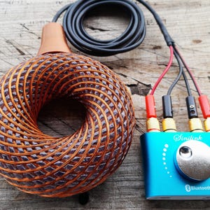 May include: A toroidal copper wire coil with a woven pattern connected by a black cable to a rectangular blue Sinilink control module. The module features a silver circular knob, four colored wire connectors, and a Bluetooth logo printed on the front.