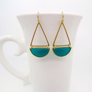 May include: Gold earrings with a teal blue half-circle pendant and a triangle frame.
