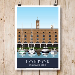 Puede incluir: Una ilustración colorida de St. Katharine Docks en Londres, Inglaterra. La ilustración presenta un edificio de ladrillo con una torre de reloj y varios barcos atracados frente a él. El texto "LONDON ST KATHARINE DOCKS" está impreso debajo de la ilustración.