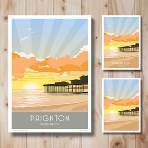 Puede incluir: Una ilustración colorida de un muelle con una puesta de sol en el fondo. El texto "Paignton South Devon" está en la parte inferior de la imagen.