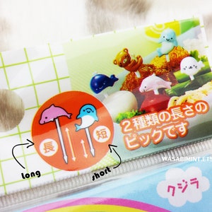 Puede incluir: Un juego de dos pinchos para comida de pl&aacute;stico de colores con dise&ntilde;o de delf&iacute;n y ballena. Los pinchos est&aacute;n disponibles en dos longitudes, larga y corta, como se indica en el embalaje. El embalaje tambi&eacute;n incluye el texto "2 種類の長さのピックです" que se traduce como "Dos tipos de pinchos".