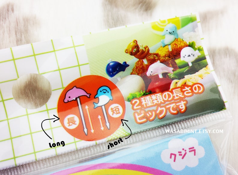 Puede incluir: Un juego de dos pinchos para comida de pl&aacute;stico de colores con dise&ntilde;o de delf&iacute;n y ballena. Los pinchos est&aacute;n disponibles en dos longitudes, larga y corta, como se indica en el embalaje. El embalaje tambi&eacute;n incluye el texto "2 種類の長さのピックです" que se traduce como "Dos tipos de pinchos".
