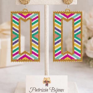 Puede incluir: Pendientes rectangulares con cuentas con un marco dorado y un colorido patrón de chevrón en rosa, amarillo, turquesa y morado. Los pendientes se exhiben en un soporte blanco con un perno dorado. Una tarjeta con el texto "Patrizia Bijoux" está en la base.