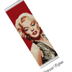 Könnte beinhalten: Ein Armband aus Perlen mit einem pixeligen Bild von Marilyn Monroe in einem rot-weißen Kleid. Das Armband ist aus kleinen Perlen gefertigt und hat einen silbernen Metallverschluss. Der Text "Patrizia Bijoux" ist in der unteren rechten Ecke des Bildes gedruckt.