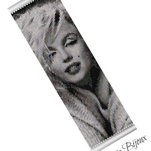 Pode incluir: Pulseira de contas preto e branco com um retrato de Marilyn Monroe. A pulseira é feita com contas pequenas e redondas e tem uma aparência texturizada e pixelada. O texto "Patrizia Bijoux" é visível na parte inferior da imagem.