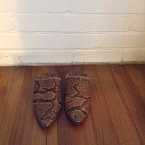 May include: A pair of brown and black snakeskin leather mules with pointed toes.