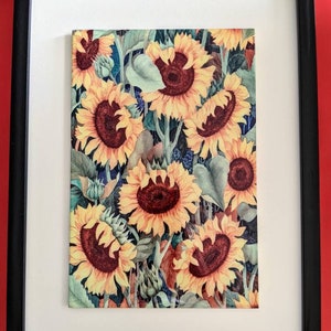 May include: Framed print of a watercolour painting featuring a close-up of a cluster of sunflowers with yellow petals and dark brown centres. The sunflowers are arranged in a dense pattern, creating a vibrant and colourful image.
