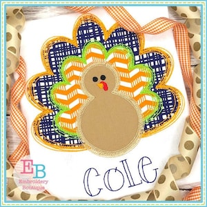 May include: Embroidered design of a brown turkey with orange, white, and green feathers. The turkey is surrounded by a blue and orange patterned border. The name "COLE" is embroidered below the turkey.