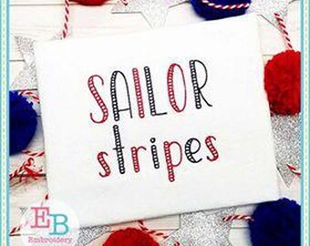 May include: White fabric with the words "SAILOR stripes" in red and black lettering. The design is surrounded by red, white, and blue pom-poms and silver star-shaped decorations.