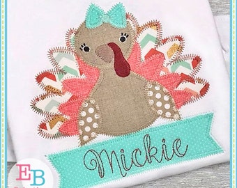 Puede incluir: Diseño de aplique de un pavo marrón con un lazo turquesa, plumas rosas y naranjas y lunares blancos. El pavo sostiene una pancarta turquesa con el nombre "Mickie" bordado en marrón.