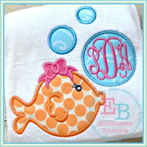 May include: Orange and white polka dot fish with a pink bow on its head, blowing bubbles. The fish is next to a blue circle with a pink monogram "LL" inside. The text "Embroidery Boutique" is at the bottom of the image.