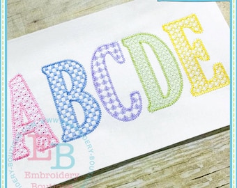 May include: Embroidered letters A, B, C, D, and E in a rainbow of colors with a gingham pattern. The letters are stitched on a white background. The text "EB Exclusive" is in the upper right corner of the image.