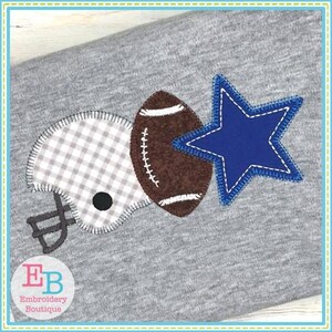 May include: Embroidered design featuring a football, a helmet, and a blue star. The design is stitched on a gray fabric.