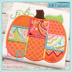 May include: A patchwork pumpkin applique embroidery design with orange, pink, green, and blue fabric pieces. The design is outlined in orange thread and features a green stem. The text "EB Exclusive" is in the top right corner of the image.