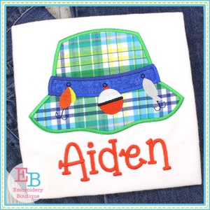 May include: A white t-shirt with a green, blue, and red embroidered fishing hat and the name "Aiden" in orange embroidery.
