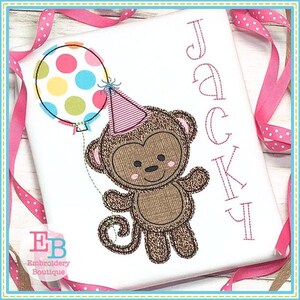 May include: Embroidered design of a brown monkey wearing a pink party hat and holding a colorful balloon. The name "Jacky" is embroidered in pink lettering on the right side of the design.