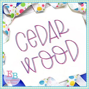 May include: Embroidered design of the name "CEDAR WOOD" in a double outline style. The outline is in pink and blue thread. The design is on a white fabric background.