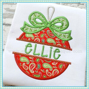 May include: A red and green Christmas bauble with a green bow and the name "Ellie" written on it.