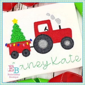 Può includere: Un trattore rosso giocattolo che tira un carro con un albero di Natale verde e luci. Il carro è rosso con ruote nere. Il trattore ha ruote nere e uno scarico nero con fumo grigio. Il testo "Ebaney Kate" è ricamato in verde sotto il trattore.