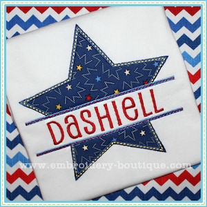 Può includere: Una maglietta bianca con un design a stella blu e il nome "Dashiell" ricamato in rosso al centro.
