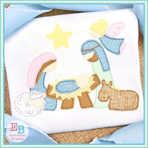 May include: A colorful embroidered design of the nativity scene with a star, angel, Mary, Joseph, baby Jesus, a sheep, and a donkey. The design is stitched on a white fabric.
