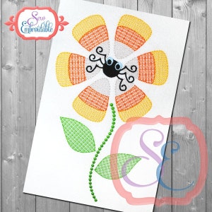 May include: A Halloween-themed embroidery design featuring a candy corn flower with a spider in the center. The flower has six petals, each with alternating stripes of orange, yellow, and white. The spider is black with white eyes and eight legs. The flower has a green stem with two leaves.