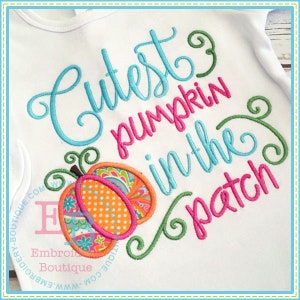 May include: Embroidered design on a white fabric featuring a pumpkin with a paisley pattern and the text "Cutest pumpkin in the patch" in pink, blue, and green.