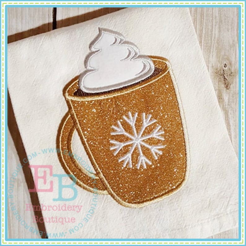 May include: A brown and gold mug with a white snowflake design and a swirl of white whipped cream on top.