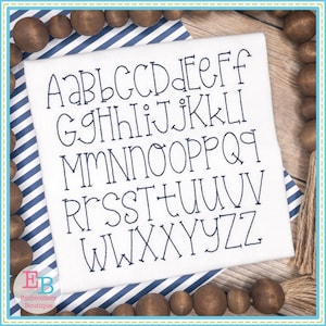 May include: A white fabric with a black outline of the alphabet in a simple, rounded font. The letters are arranged in alphabetical order.