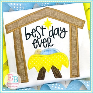 May include: Embroidered design of a manger with a baby inside, a star above, and the text "best day ever".