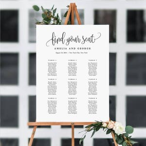 May include: A white wedding seating chart with black text. The chart is titled "Find Your Seat" and lists the names of guests at each table. The wedding is for Amelia and George and is taking place on August 15, 2015 in New York City.