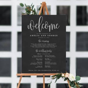 Puede incluir: Un letrero de pizarra negra con texto blanco anunciando la boda de Amelia y George el 18 de agosto de 2018. El letrero enumera los detalles de la ceremonia y la fiesta de bodas.