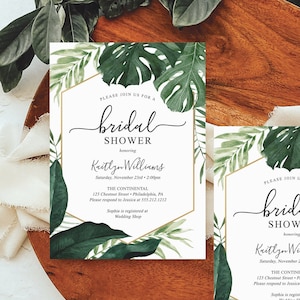 May include: Two white cards with gold accents and green tropical leaf illustrations. The text on the cards reads "Please join us for a bridal shower honoring Kaitlyn Williams. Saturday, November 23rd 2:00pm. The Continental 123 Chestnut Street Philadelphia, PA. Please respond to Jessica at 355.212.1212. Sophia is registered at Wedding Shop."