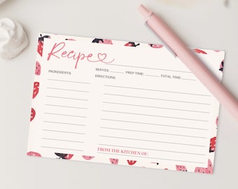 May include: A recipe card with a watermelon pattern and the word "Recipe" in pink script. The card has lines for ingredients, servings, prep time, and total time. A pink pen rests on the card. White meringues and a pink rose are in the background.