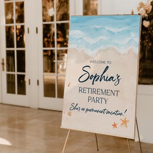 May include: A welcome sign for Sophia's retirement party, featuring a beach-themed watercolor design. The sign includes the text "Welcome to Sophia's Retirement Party" and "She's on permanent vacation!" displayed on a gold easel.