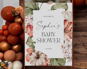 Könnte beinhalten: Ein Babyparty-Schild mit dem Text "Welcome to Sophia's Baby Shower", umgeben von floralen Illustrationen. Das Schild wird von einer Kupferstruktur umrahmt, mit Ballons in Orange-, Weiß- und Goldtönen auf der linken Seite.