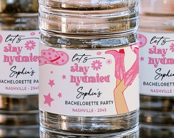 Puede incluir: Tres botellas de agua de plástico transparente con etiquetas rosas y blancas que dicen "Let's stay hydrated" y "Sophin's Bachelorette Party" con un gráfico de bota de vaquero y sombrero rosa.